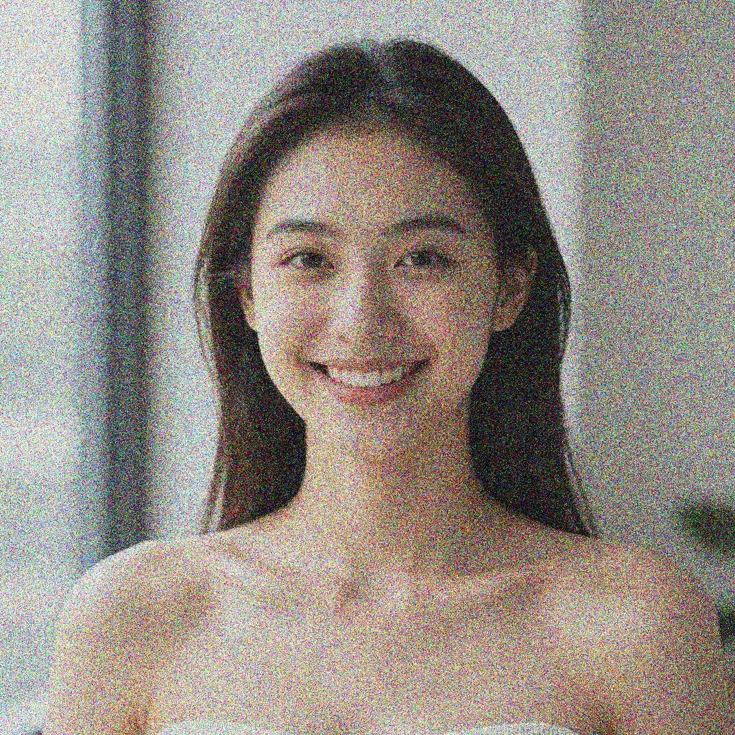 Grainy low-light portrait shot at high ISO with heavy color noise across the face before AI noise reduction